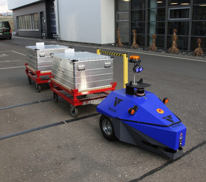 Transportroboter INDUROS als autonomer Routenzug mit zwei Anhängern auf dem Werksgelände