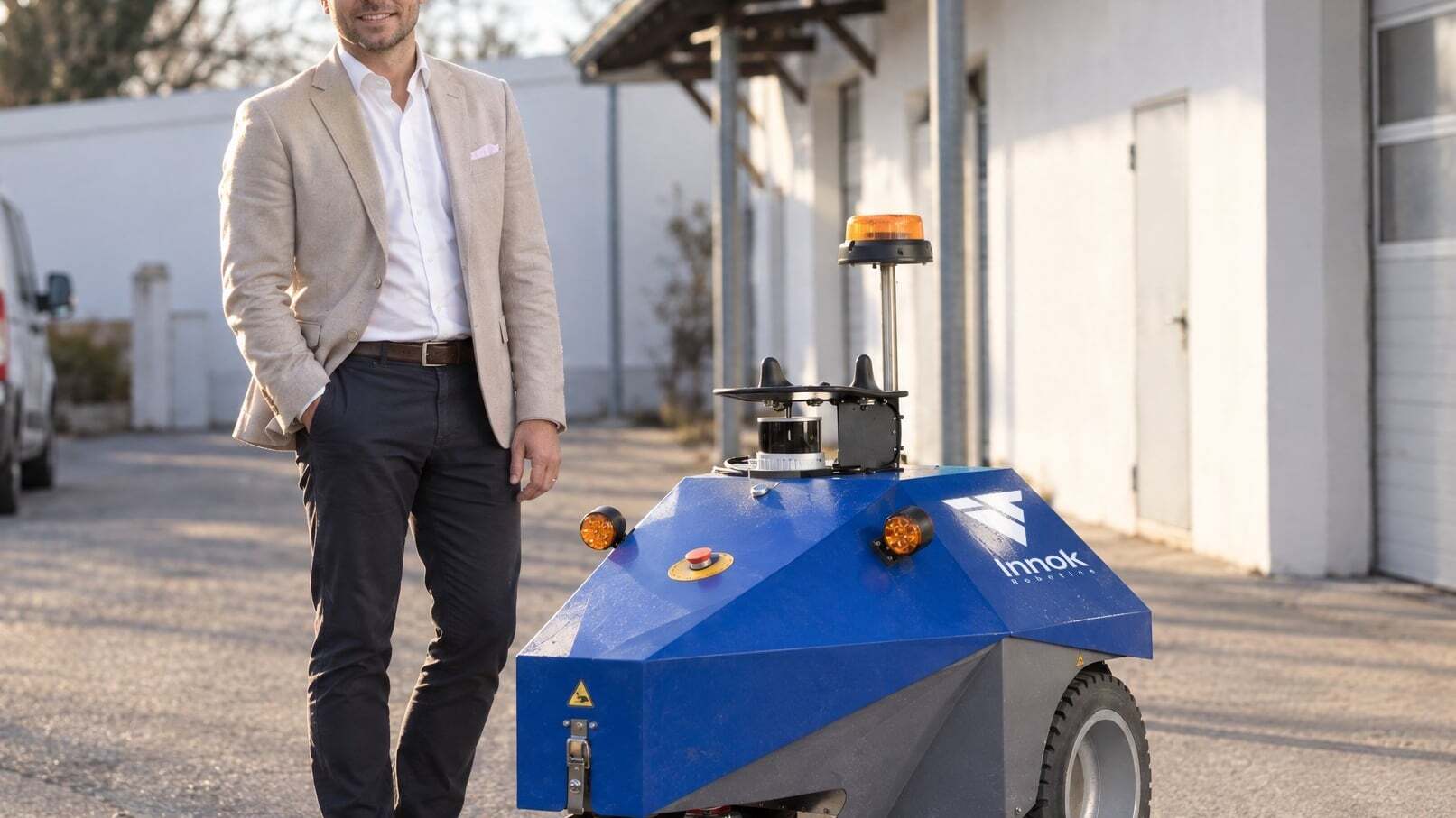 Michael Hanselmann, neuer CFO von Innok Robotics, neben dem autonomen Transportroboter INDUROS