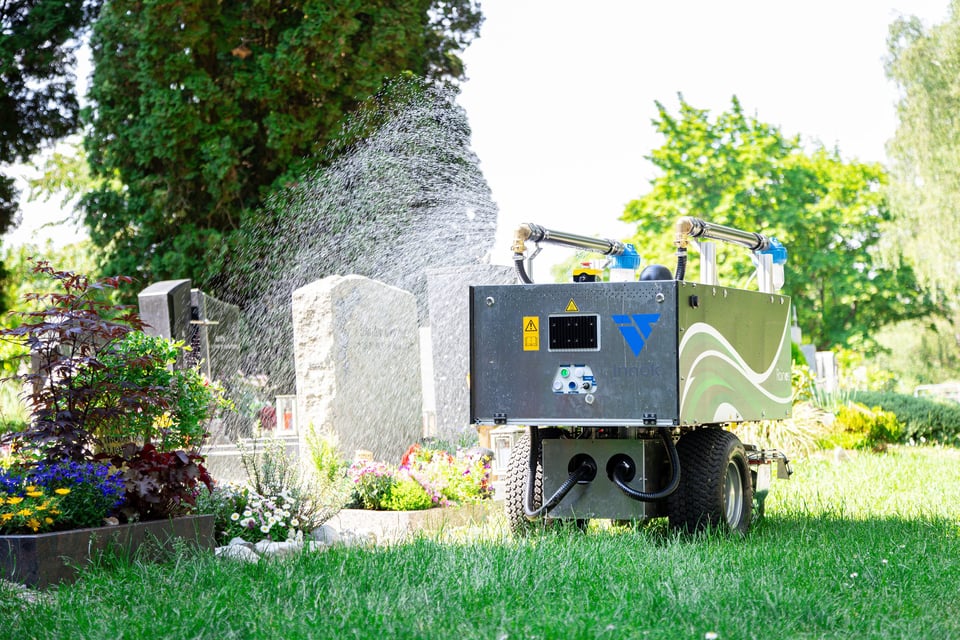 RAINOS watering robot watering a grave in a cemetery